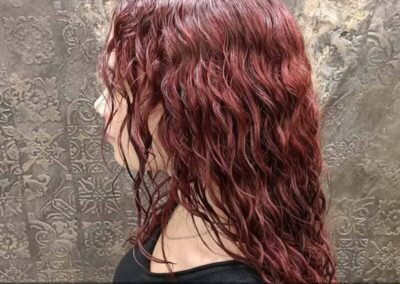 Cheveux bouclés couleur bordeaux avec soin Olaplex