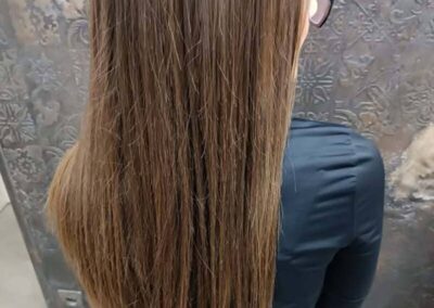 Femme aux cheveux longs et lisses de dos.